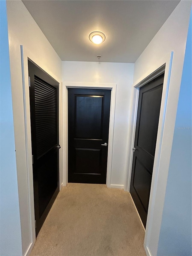 hallway with baseboards and carpet flooring