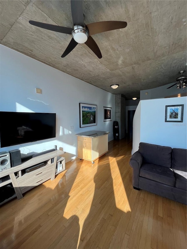 living area with wood finished floors and ceiling fan