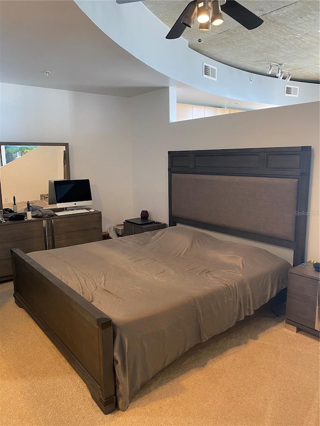 bedroom with visible vents, a ceiling fan, and light carpet