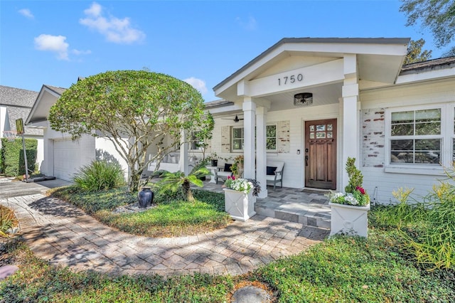 entrance to property with covered porch and a garage