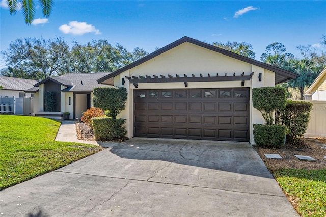 ranch-style house with a garage, concrete driveway, a front yard, and stucco siding