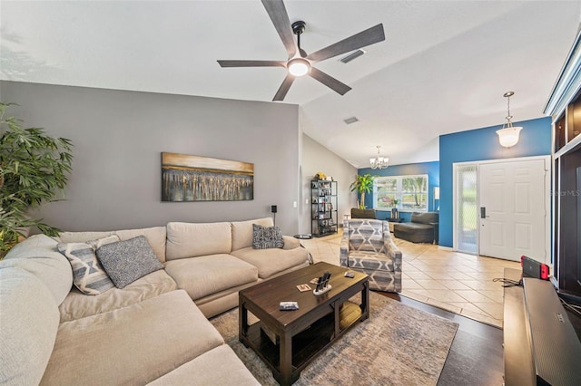 tiled living room featuring visible vents, vaulted ceiling, and ceiling fan with notable chandelier