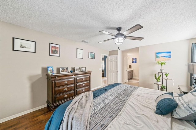 bedroom featuring visible vents, connected bathroom, a textured ceiling, wood finished floors, and baseboards