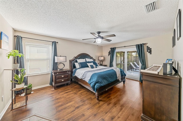 bedroom with access to exterior, visible vents, ceiling fan, wood finished floors, and baseboards