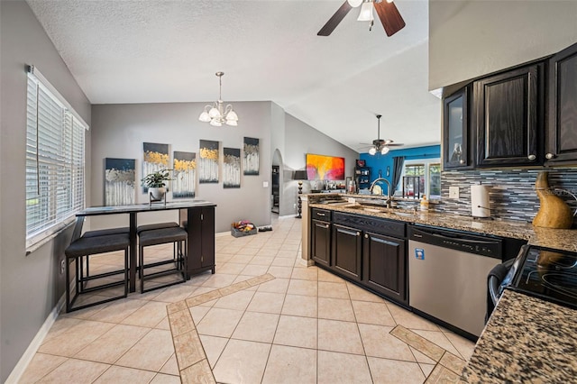 kitchen featuring dishwasher, a peninsula, a sink, and light tile patterned floors