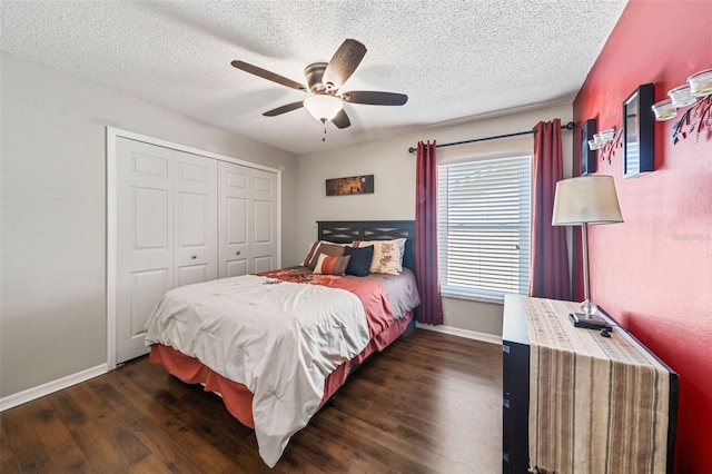 bedroom featuring a textured ceiling, a ceiling fan, baseboards, a closet, and dark wood-style floors