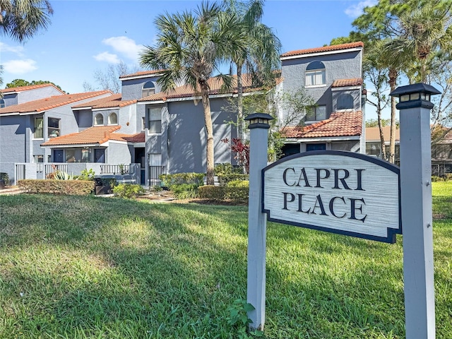 community sign featuring a residential view and a lawn