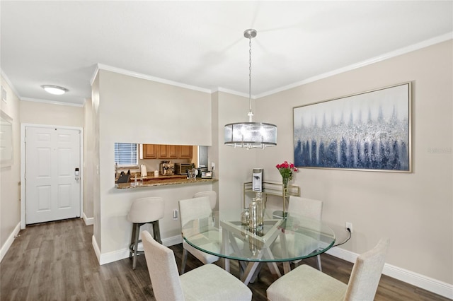 dining room with dark wood-type flooring, crown molding, and baseboards