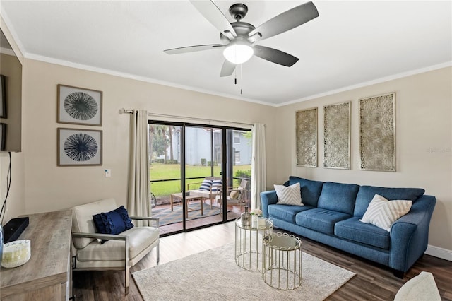 living area featuring ceiling fan, baseboards, wood finished floors, and crown molding