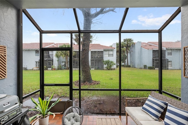 sunroom featuring a residential view and a wealth of natural light