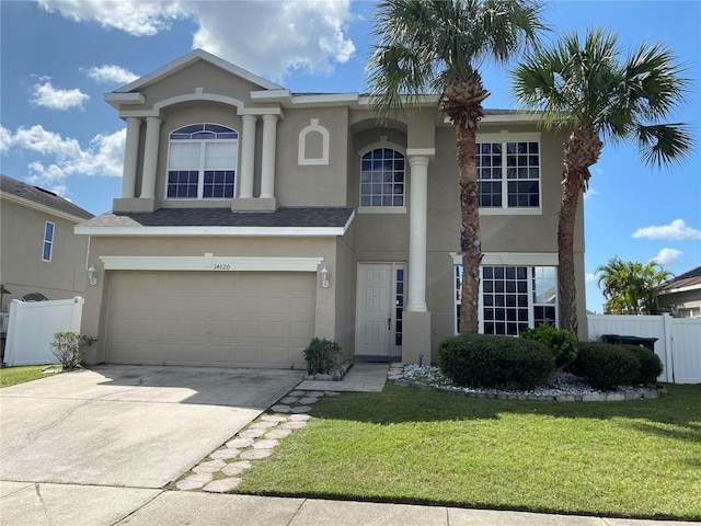 view of front of house with stucco siding, concrete driveway, an attached garage, fence, and a front lawn