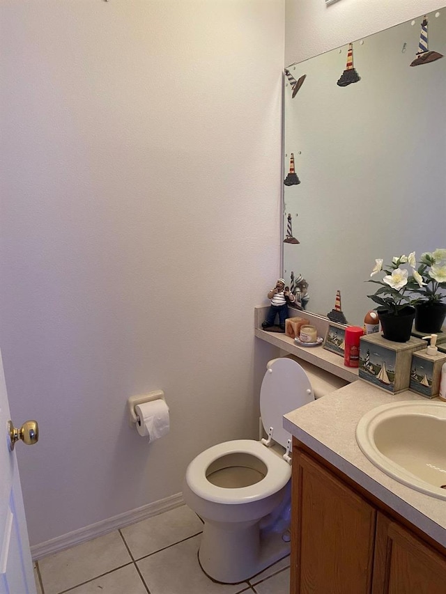 half bath featuring tile patterned flooring, baseboards, vanity, and toilet