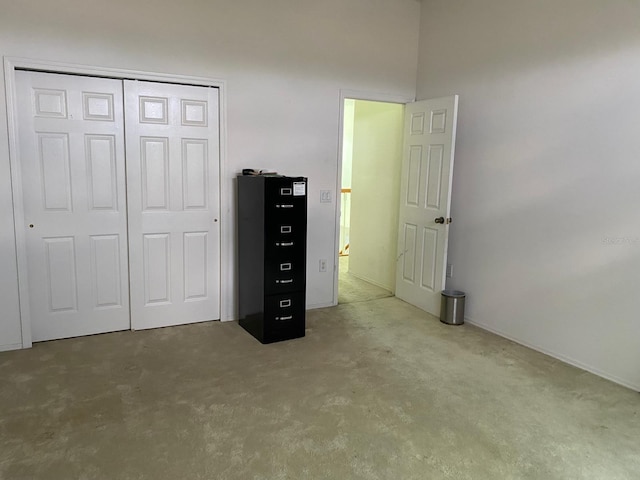 unfurnished bedroom featuring concrete flooring and a closet