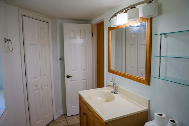 bathroom with a closet, vanity, toilet, and tile patterned floors