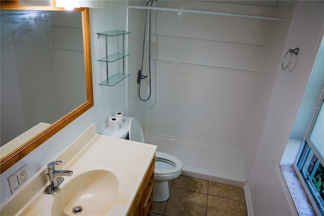 bathroom featuring toilet, a stall shower, tile patterned flooring, and vanity