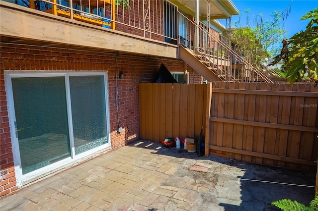 view of patio / terrace with stairway and fence