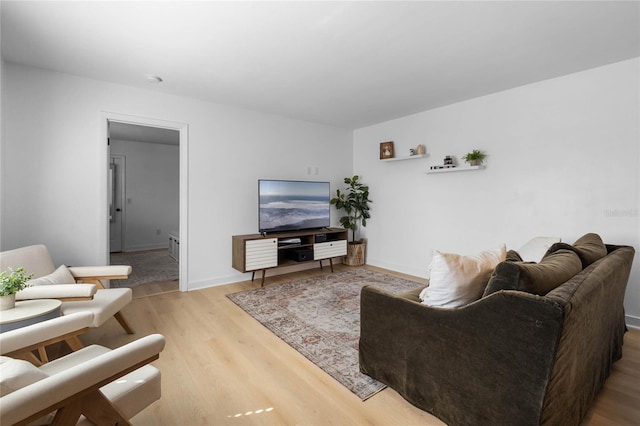 living area with baseboards and light wood finished floors