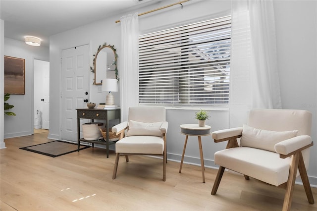 sitting room featuring baseboards and light wood-style floors