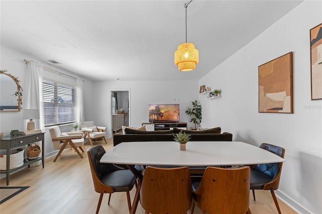 dining room with visible vents, baseboards, and light wood finished floors