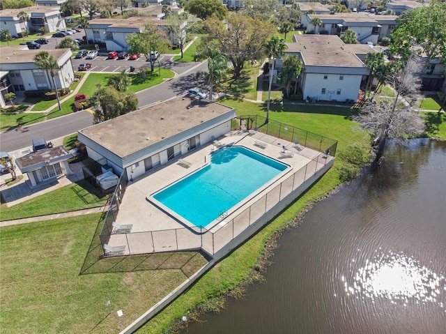 pool with a residential view, a water view, and fence