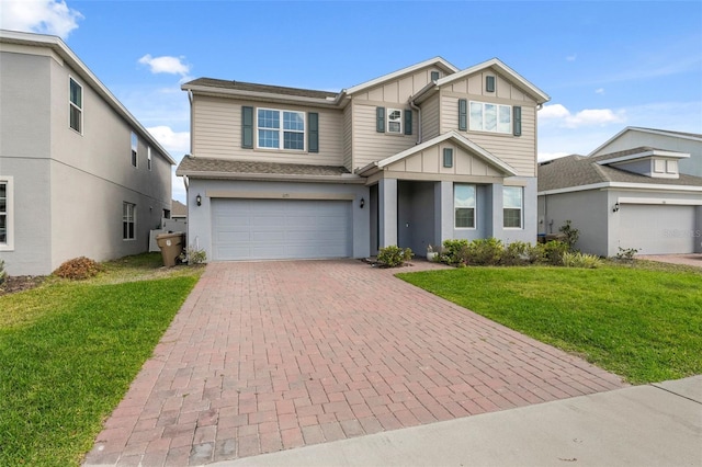 view of front of property featuring a garage, a front lawn, decorative driveway, and board and batten siding