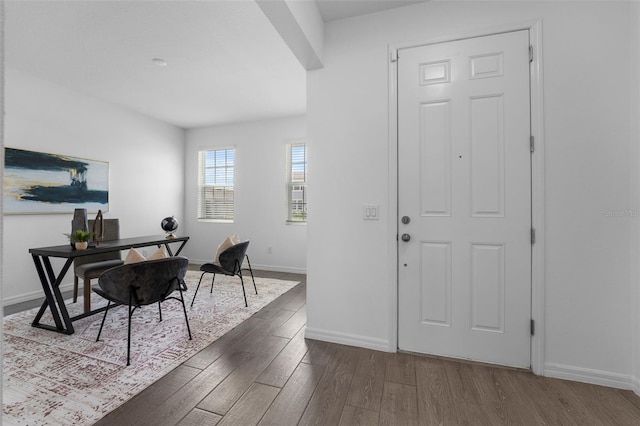 foyer featuring dark wood-type flooring and baseboards