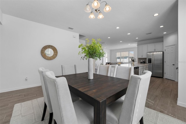 dining room with recessed lighting, visible vents, wood finished floors, a chandelier, and baseboards