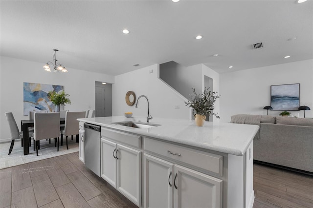 kitchen with dark wood-style floors, visible vents, stainless steel dishwasher, open floor plan, and a sink