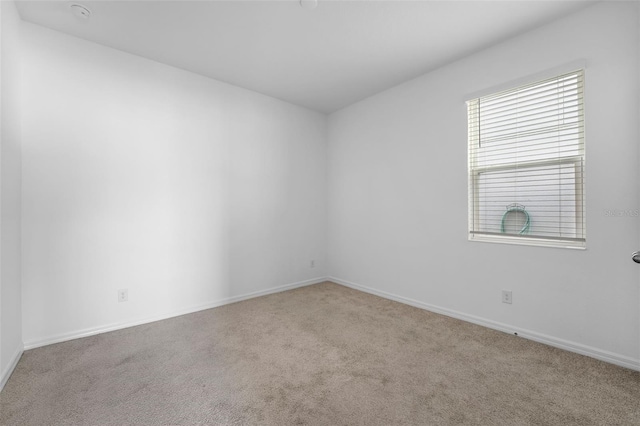 carpeted empty room with baseboards