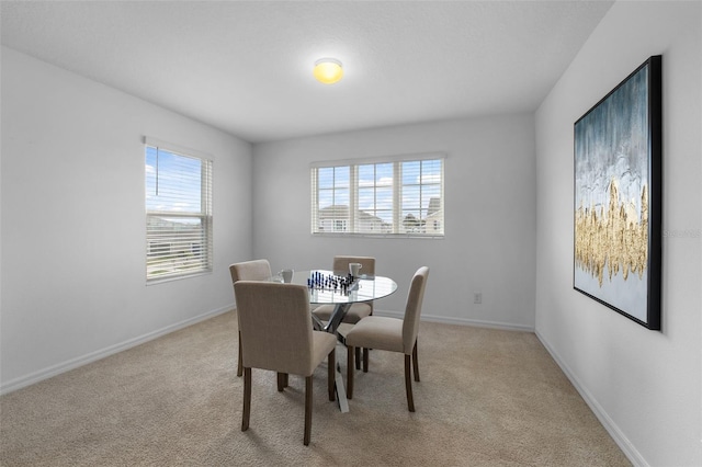 dining room with light carpet, baseboards, and a wealth of natural light