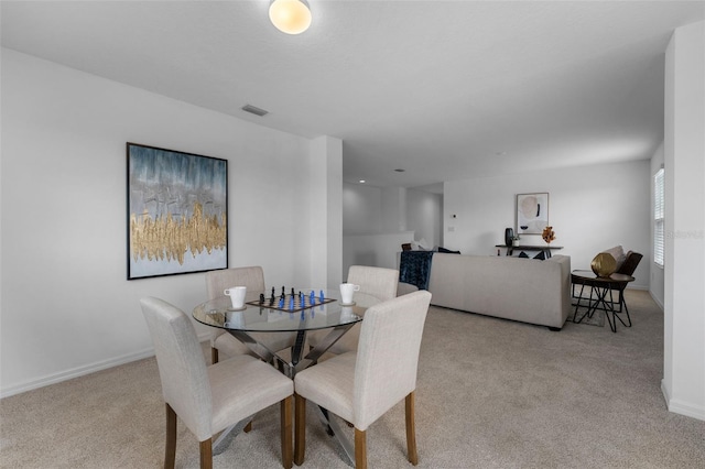 carpeted dining room featuring visible vents and baseboards