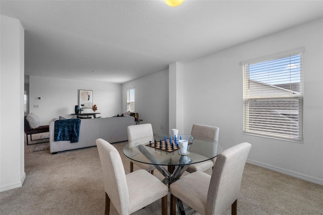 dining space featuring baseboards and carpet flooring