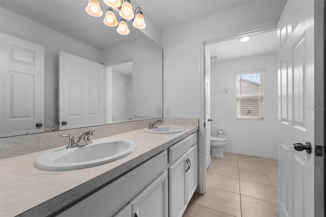 bathroom with double vanity, a sink, toilet, and tile patterned floors