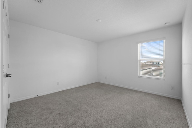 unfurnished room with carpet and baseboards