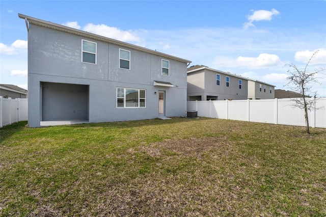 back of property with a yard, cooling unit, a fenced backyard, and stucco siding