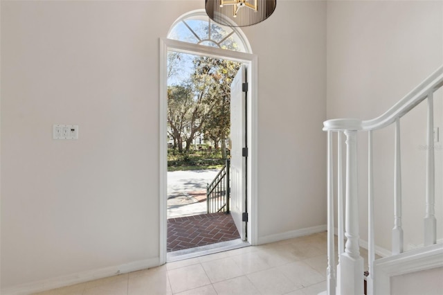 entryway with tile patterned floors, baseboards, and stairs