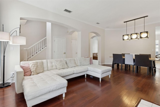 living room with ornamental molding, visible vents, and hardwood / wood-style flooring