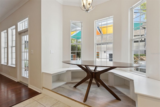 dining room featuring ornamental molding, breakfast area, wood finished floors, and a wealth of natural light