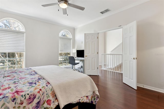 bedroom with visible vents, ornamental molding, ceiling fan, wood finished floors, and baseboards