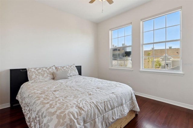 bedroom with dark wood-style floors, ceiling fan, and baseboards