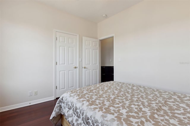 bedroom featuring dark wood-style floors and baseboards