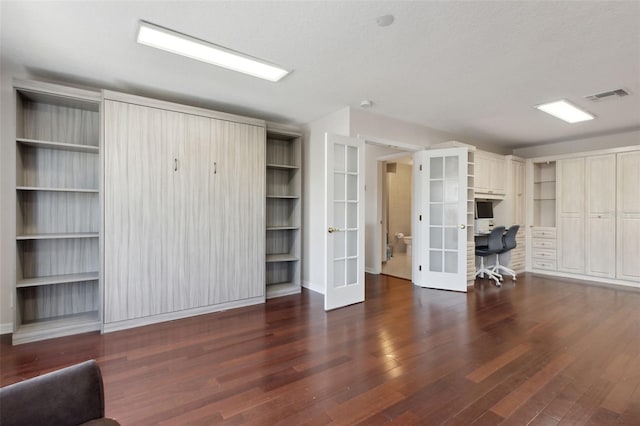 interior space with french doors, visible vents, and wood finished floors