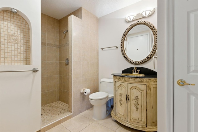 full bath featuring tile patterned flooring, a tile shower, vanity, and toilet