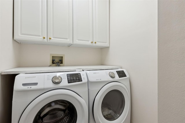 washroom featuring separate washer and dryer and cabinet space