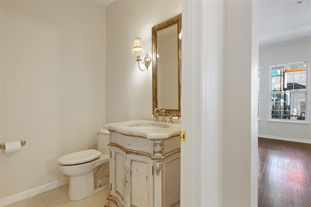 bathroom featuring baseboards, vanity, and toilet