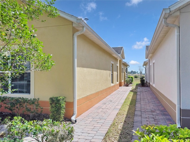 view of side of home featuring a patio and stucco siding