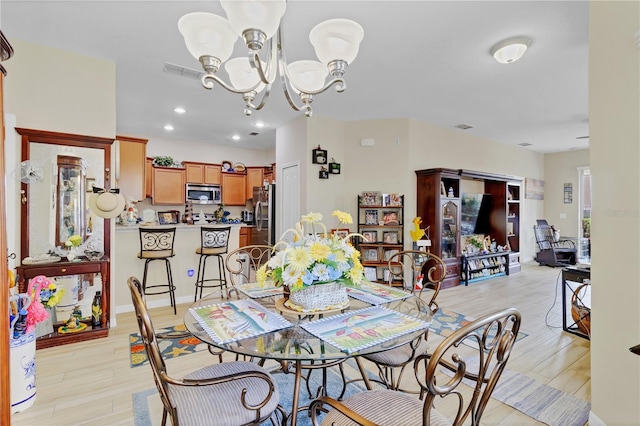 dining room featuring light wood-type flooring, visible vents, a notable chandelier, and recessed lighting