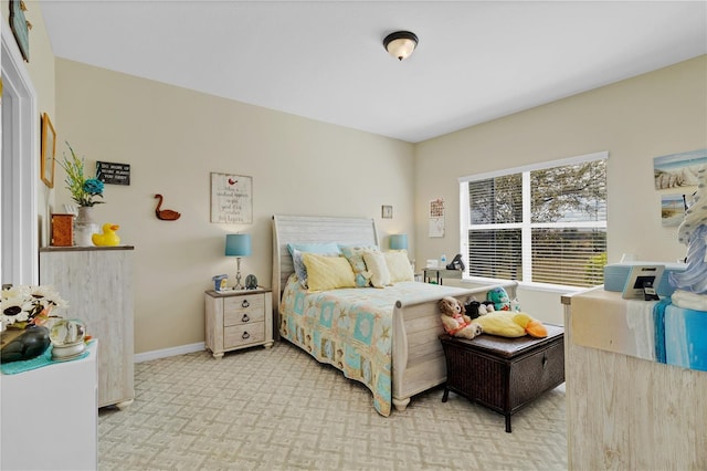 bedroom with baseboards and light colored carpet