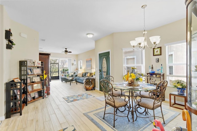 dining space featuring ceiling fan with notable chandelier, light wood-type flooring, and baseboards