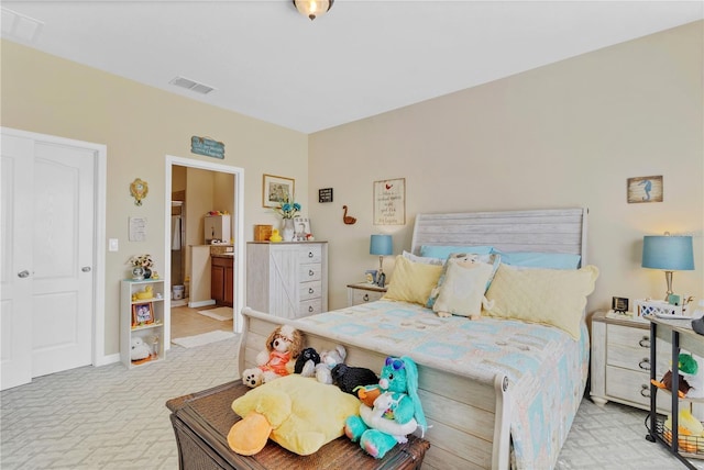 carpeted bedroom featuring baseboards, visible vents, and ensuite bathroom